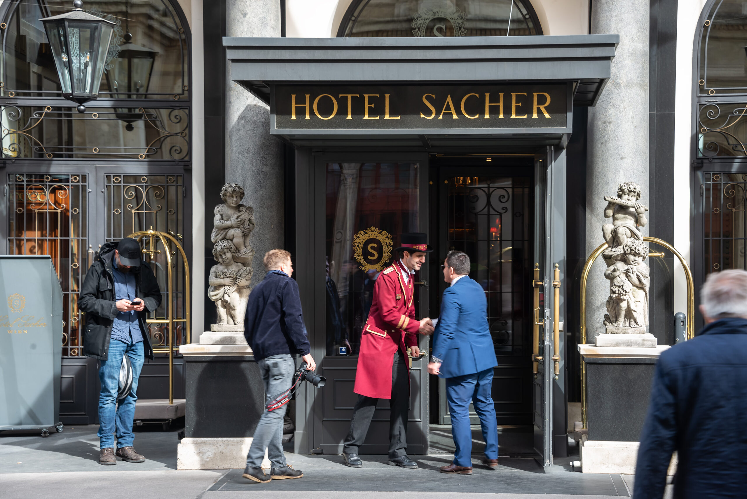 Vienna Austria 11.03.2019 : Porter in red uniform next to the sacher hotel door waiting guests